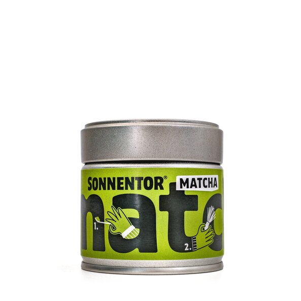 On the small tin can there is a green label with the black inscription "matcha". The preparation steps are shown with symbols in the letters.